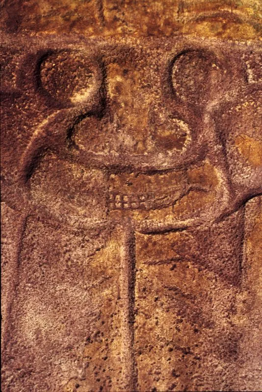 Parte inferior de la estatua de la fecundidad de la Mesita B. La madre tierra, en posición invertida y con una larga línea vertical que representa la vagina, sostiene de forma natural las piernas con los brazos, presta para la inseminación. El mono-serpiente aparecía parcialmente enterrado, formándose así una escultura en la que la propia tierra es, en términos físicos y simbólicos, protagonista de la obra de arte.