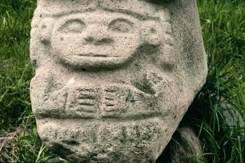La figura femenina de la estatua que representa el coito que dio origen al hombre ostenta orejeras circulares y el cabello dividido sobre la frente, rasgos que se han caracterizado como femeninos. Pero es más interesante observar que sus facciones son claramente simiescas, en particular la forma de la nariz y de la boca. Igualmente lleva a su bebé sobre la espalda, comportamiento característico de los monos cébidos.