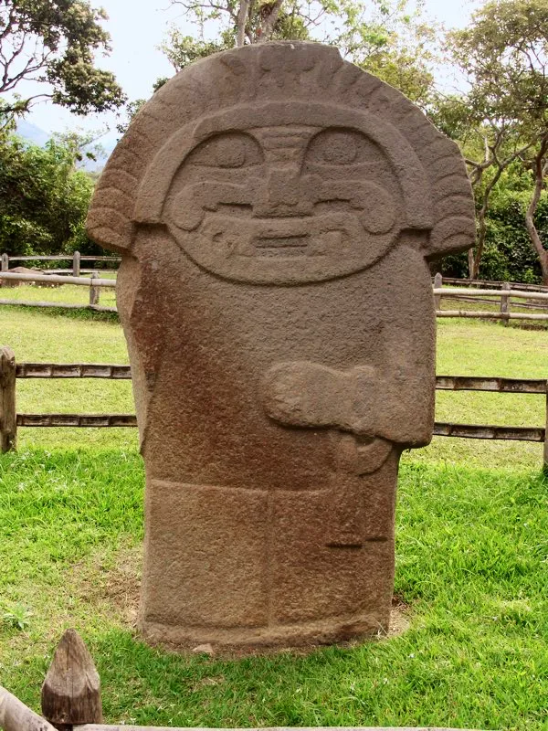 De las seis estatuas que Codazzi halló en la Mesita C del Parque Arqueológico de San Agustín, sitio que describió como “el cementerio de los sacerdotes, o tal vez el lugar de sus juntas para conferir la última enseñanza y el premio de la iniciación a los neófitos”. Sin duda son estatuas muy singulares, labradas algunas de ellas en relieve bidimensional para acentuar su carácter ultramundano, y en todos los casos con características especiales que las distinguen de las demás de la estatuaria. La figura, además de la extraña forma de sus facciones y el penacho anillado, tenía originalmente brazos asimétricos, uno de ellos por desgracia desportillado.