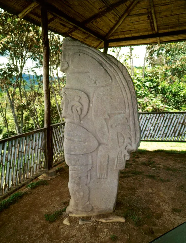 Carguero del Alto de las Piedras, con el mono-serpiente-caimán a cuestas. ?En esta estatua el mono-serpiente original, transformado en extraña entidad con ojos en forma de espiral y vistosa diadema, se proyecta hacia atrás bajo la forma de dos animales superpuestos: una serpiente decorada con círculos y estrías, cuya cola remata en la cabeza con penacho y los brazos del mono, y un caimán de poderosas fauces. Es sin duda un ser-espíritu, que hemos llamado Espíritu Multiforme, en cuyo cuerpo se combinan los animales principales de la mitología del Macizo Colombiano, procedentes todos de tierras bajas y ardientes, en demostración del origen amazónico de los pueblos que labraron las estatuas. Un ser que habla de los orígenes y del tema central de la estatuaria: la fertilidad.