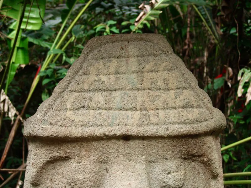 Gorro en forma de pirámide escalonada que corona una estatua originalmente en el Montículo Noroeste de la Mesita B del Parque de San Agustín. Casi idéntico al que lleva la estatua que representa la fertilización de la tierra en el mismo sitio, es probablemente distintivo del sol y, con algunas modificaciones formales, vuelve a hallarse como tocado de varias imágenes del mono-serpiente. En su forma más sencilla, reducido a un cuerpo cuadrangular, remata las cabezas de muchos “guardianes de tumbas”. No cabe duda, por lo tanto de que se trata de un símbolo solar y fálico, vinculado con la imagen del mono y de la fertilidad. Quizá por ello es la figura geométrica más común en la estatuaria. ?Un anónimo viajero de la época colonial trazó en este gorro una indescifrable leyenda.