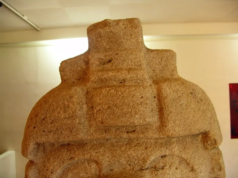 La forma de pirámide escalonada como remate de las figuras presenta variaciones interesantes como en el caso del casco de una estatua de Uyumbe, con una figura triangular sobre la frente.