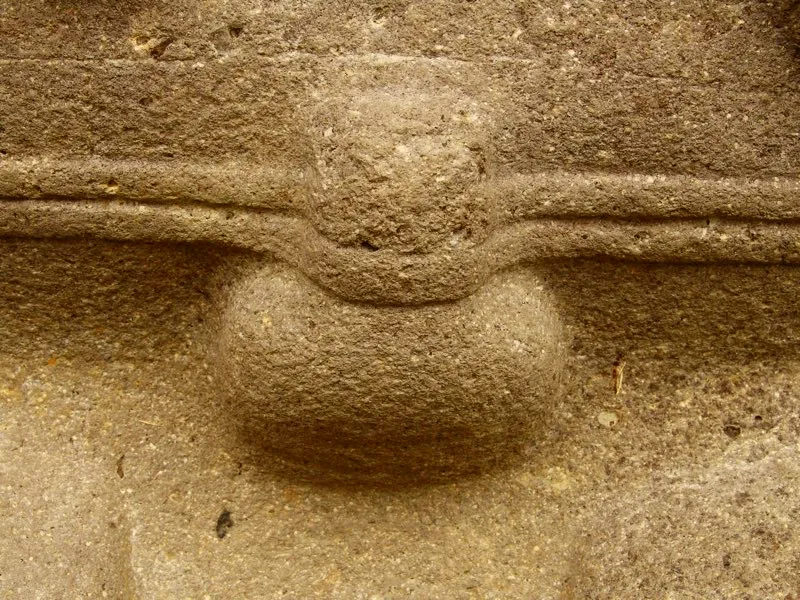 Varias figuras llevan por todo atuendo un cordón cuya función es mantener el miembro viril apuntando hacia arriba, erecto y adherido al vientre. En los cordones de la estatuaria parece haber una alusión al Espíritu Multiforme, y en particular a la serpiente y al elemento femenino, resaltada por la forma de los nudos con que se atan. No puede dejar de mencionarse, además, la similitud de dos rasgos de la figura humana, uno en la parte superior del cuerpo y otro en la inferior: la nariz y el falo sostenido por un cordón. Los dos elementos —nariz y falo— reproducen la forma básica de la pirámide escalonada.